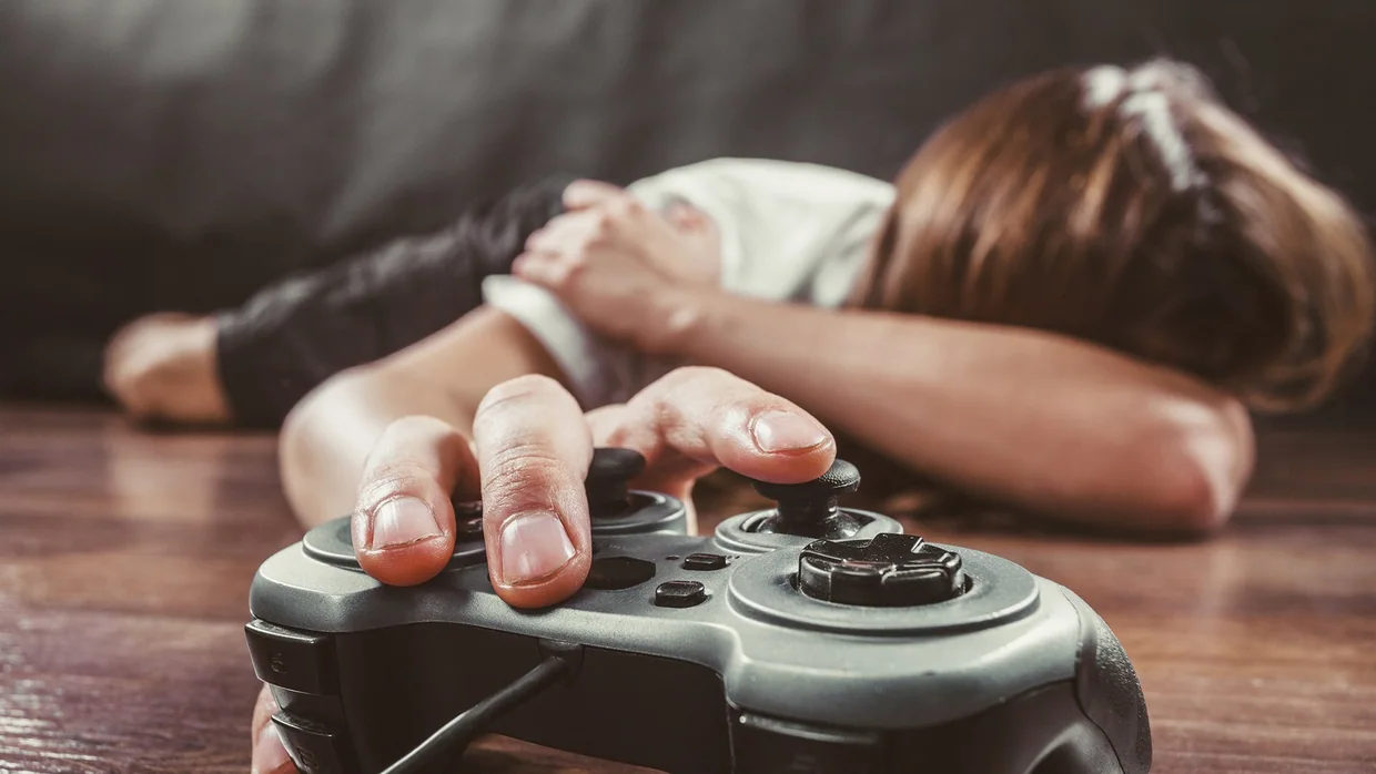 Adolescente adormecido com um comando de jogo na mão