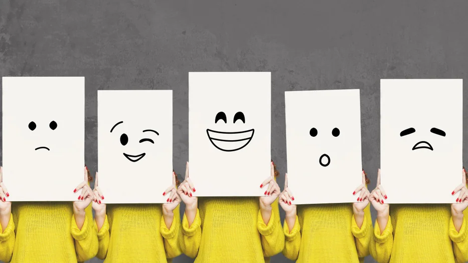 Crianças a segurar cartões com diferentes expressões emocionais