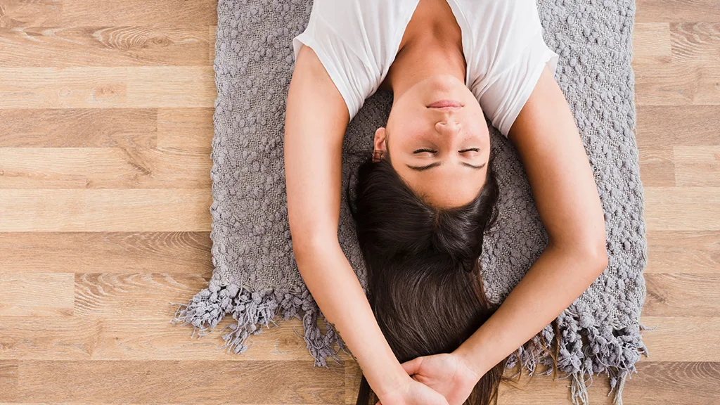 Adulto deitado, num exercício de relaxamento