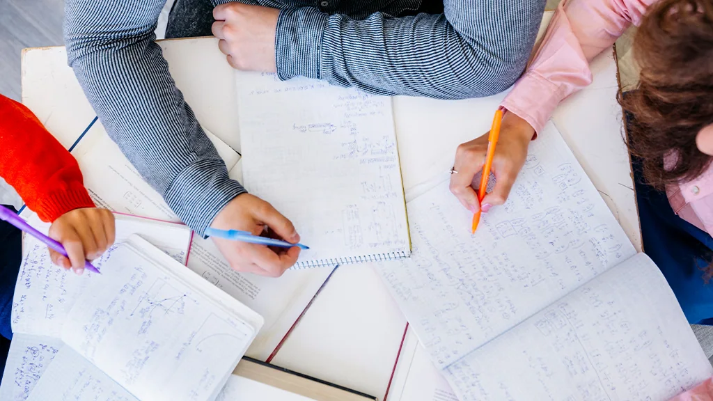 Estudantes a trabalhar sobre apontamentos e gráficos